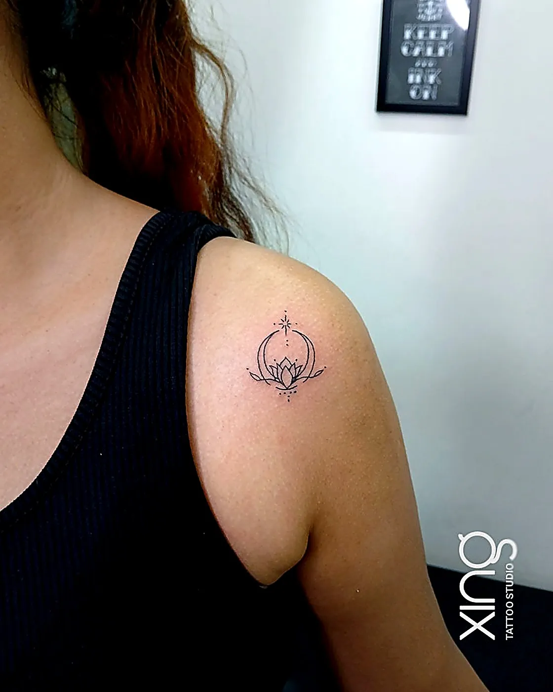 Fine-line crescent moon and lotus tattoo on shoulder