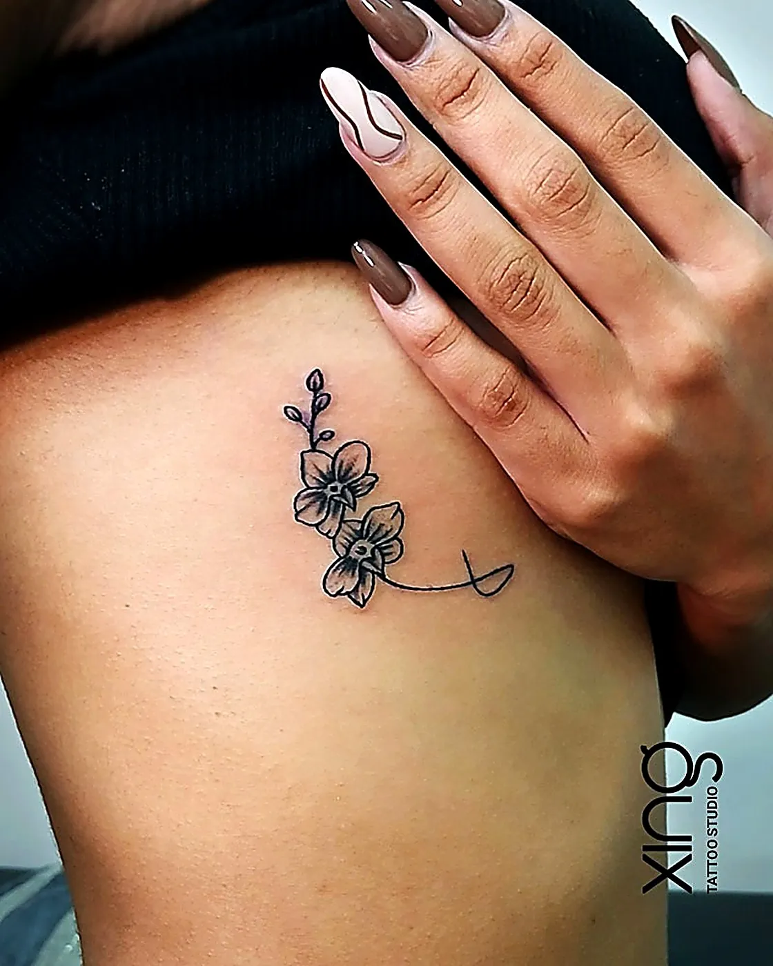 Fine-line orchid flowers tattoo on ribs