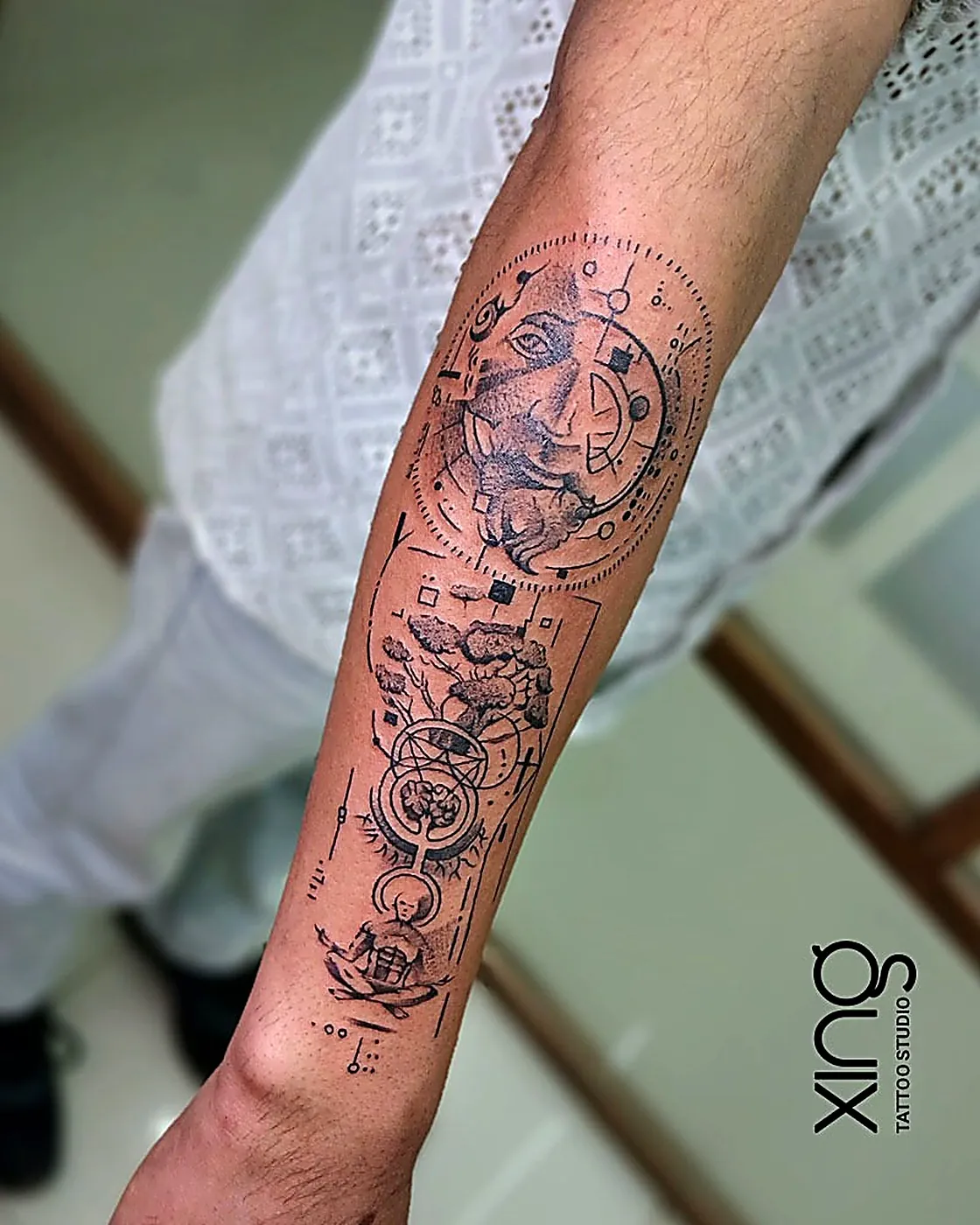 Geometric arm sleeve tattoo with rhino, tree and sacred geometry shapes