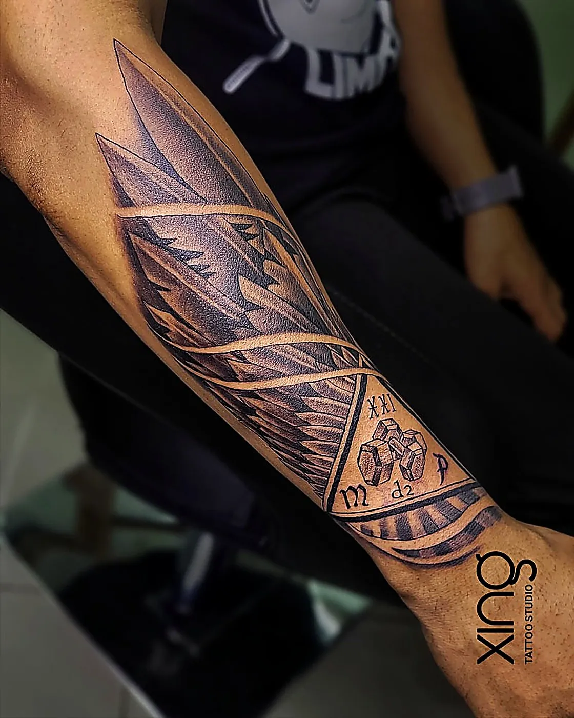 Realistic eagle wing sleeve tattoo with sunburst crown on forearm