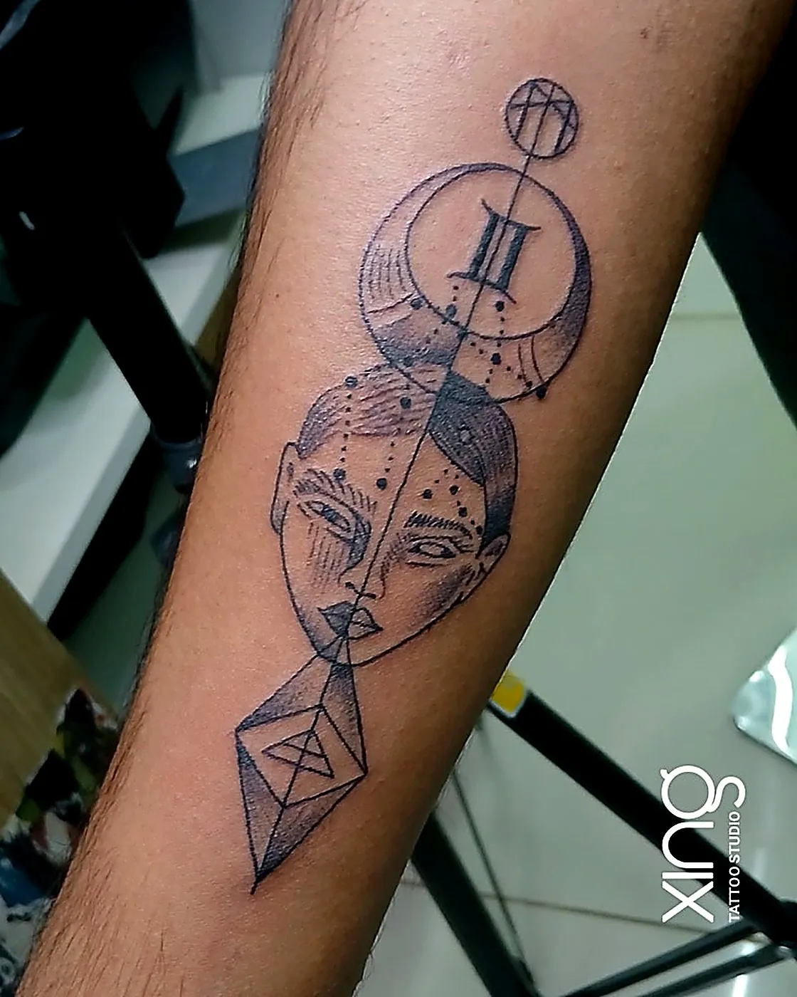 Geometric zodiac face tattoo on forearm