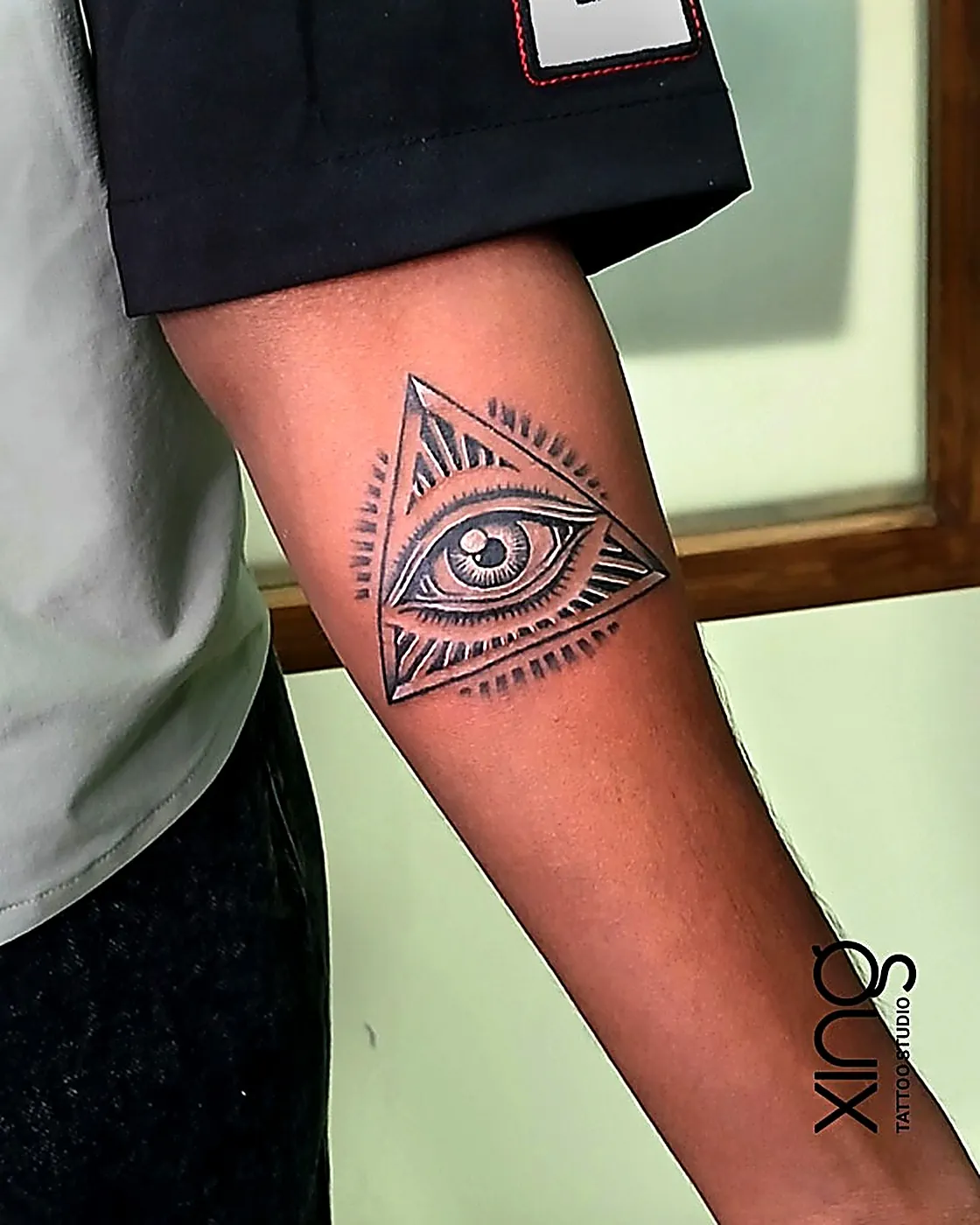 Eye of providence triangle geometric tattoo on forearm