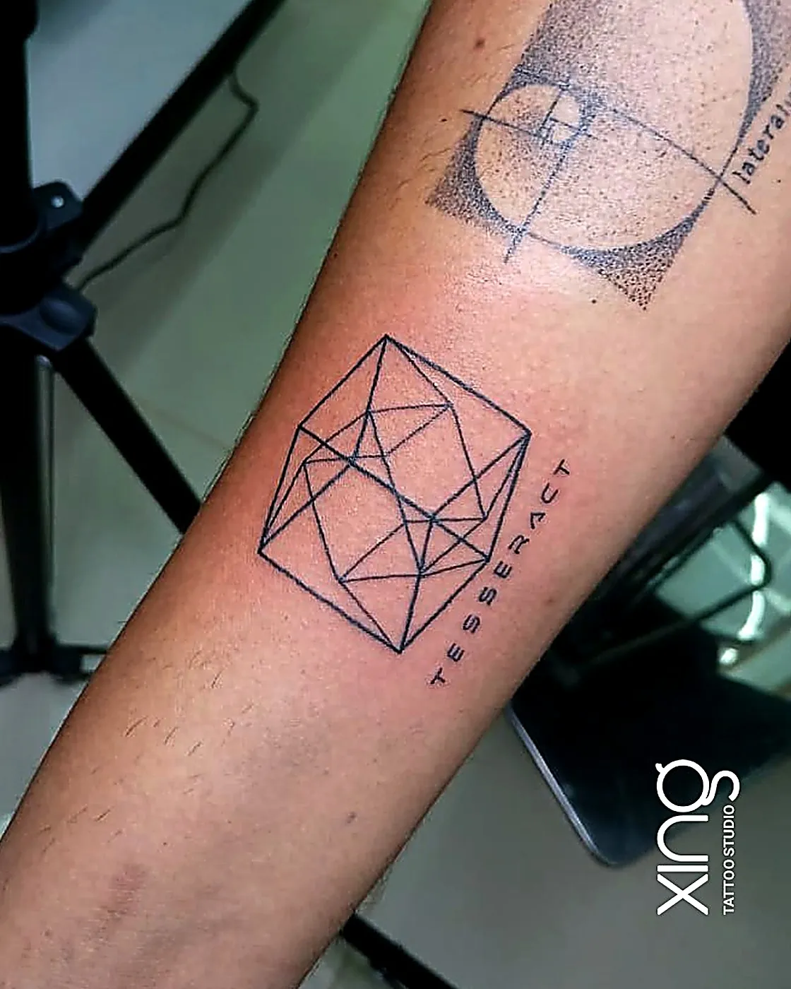 Tesseract cube geometric line tattoo on forearm