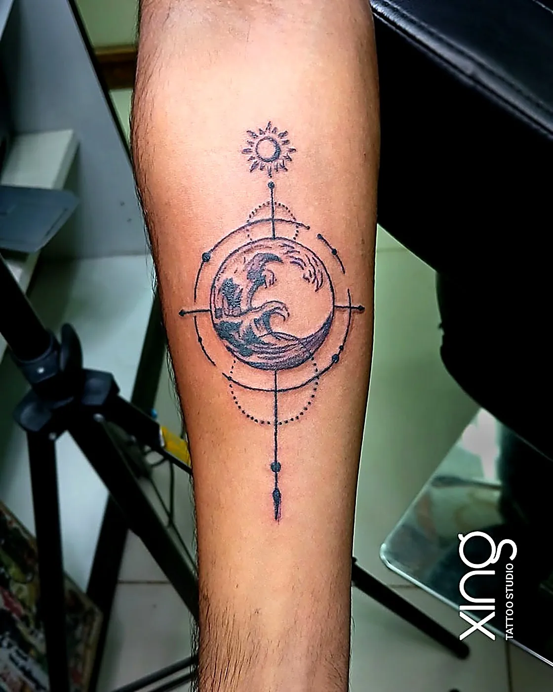 Geometric compass and wave tattoo on forearm with precise fine-line symmetry at XING Tattoo Studio, Bengaluru